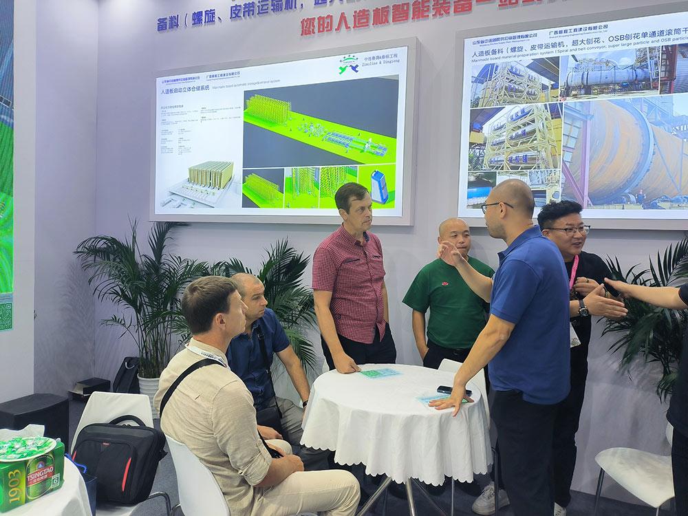 Des clients russes discutent de la technologie et des activités d'une ligne d'emballage automatique pour l'industrie des panneaux artificiels lors d'une exposition sur le travail du bois Russia Clients Discussing The Technology And Business Of Automatic Packaging Line For Manmade Board Industry In Woodworking Exhibition